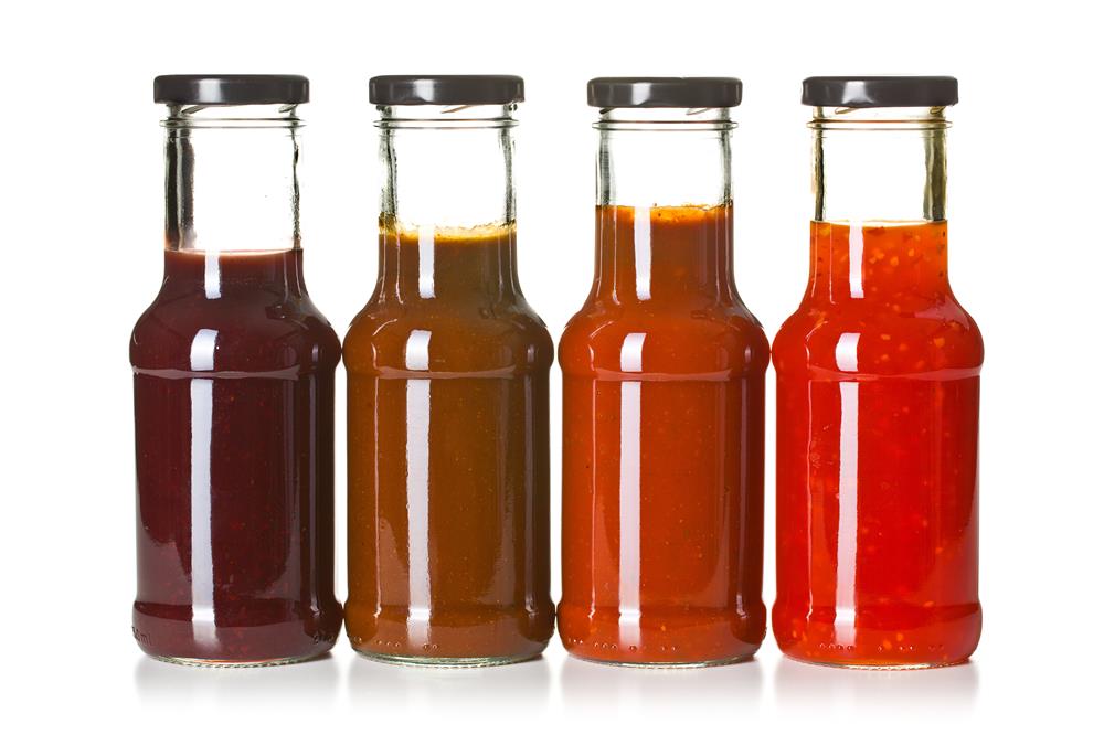 An assortment of flavors in different BBQ sauce bottles.