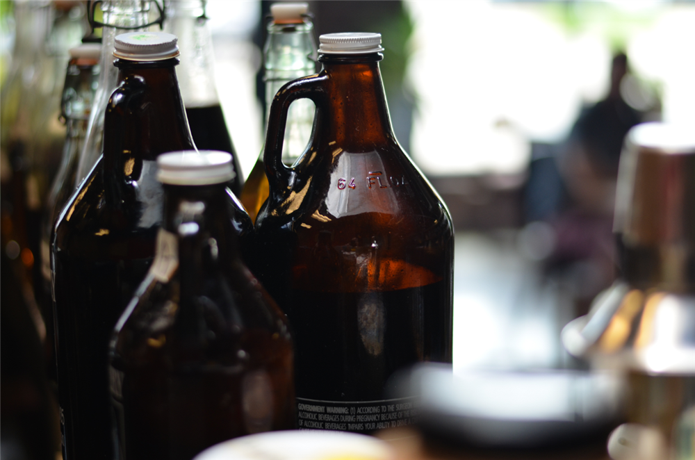 Multiple branded growler bottles with printed information on them.